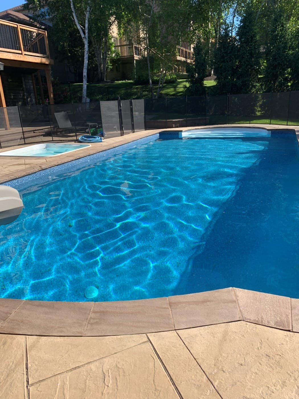 Luxury inground pool with spa and stamped concrete surround