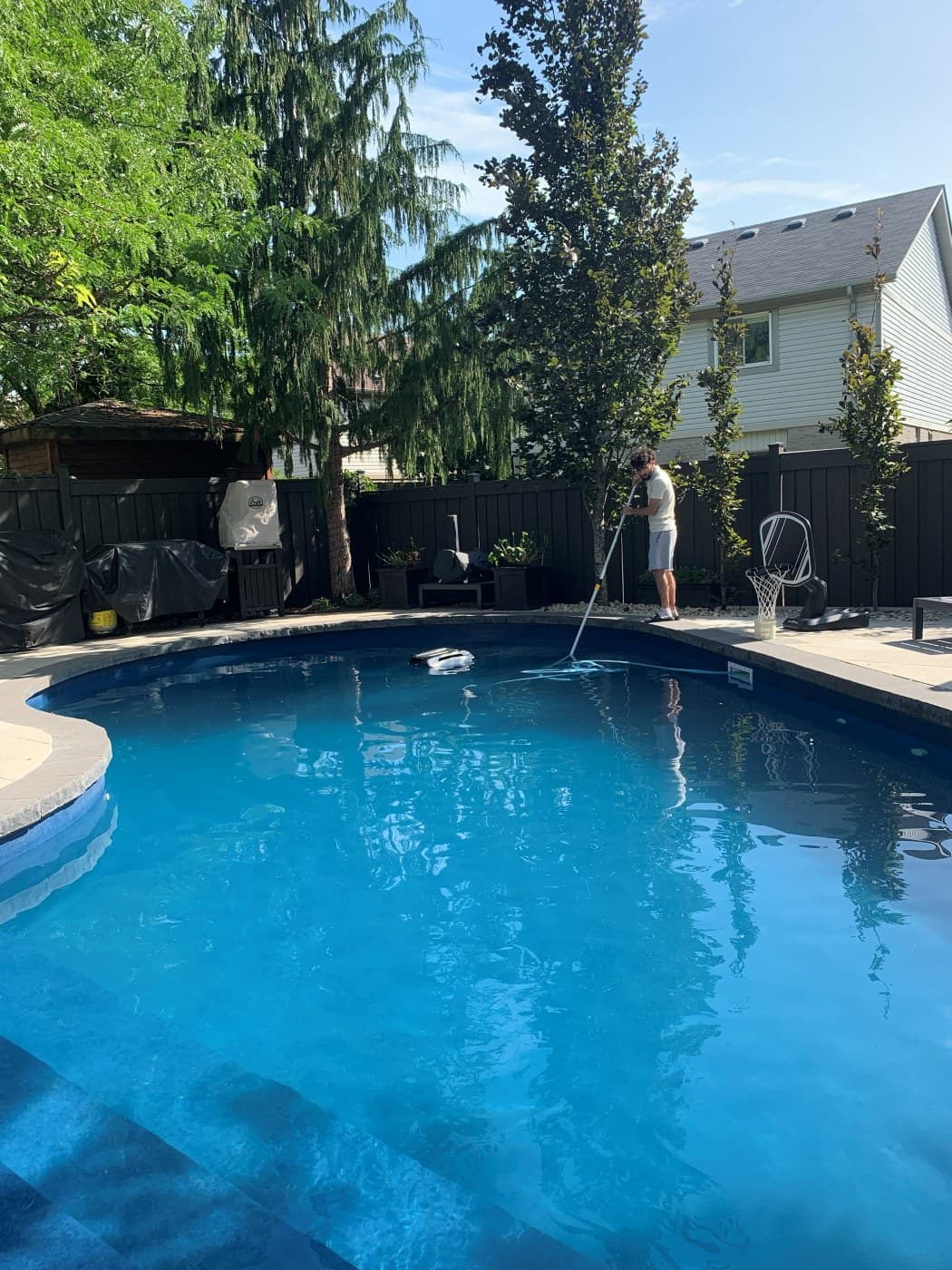 Pool Perfect technician brushing and cleaning an inground pool